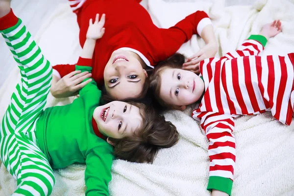 줄무늬 잠옷을 가족은 집에서 어린아이들이 소파에 — 스톡 사진