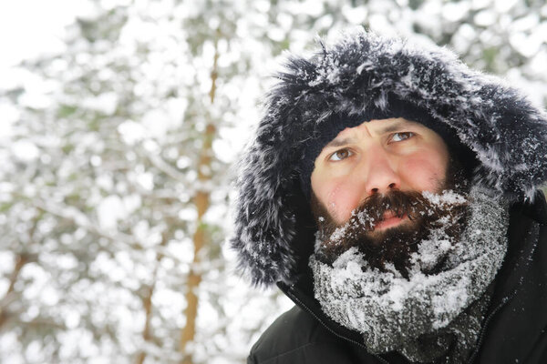 Bearded man in the winter woods. Attractive happy young man with beard walk in park.