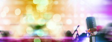 Arka planda arka ışıklandırmalı Retro tarzı mikrofon. Ses, müzik ve karaoke için klasik gümüş mikrofon. Konuşma yayın ekipmanı. Canlı pop, rock müzik performansı. Seçici odak