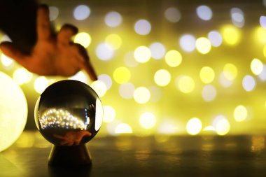 Yerde Bokeh 'le kristal küre var. Renkli ışık saçan cam top, yeni yıl kutlaması konsepti..