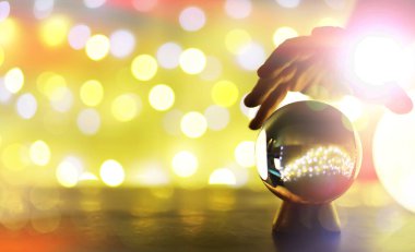 Yerde Bokeh 'le kristal küre var. Renkli ışık saçan cam top, yeni yıl kutlaması konsepti..