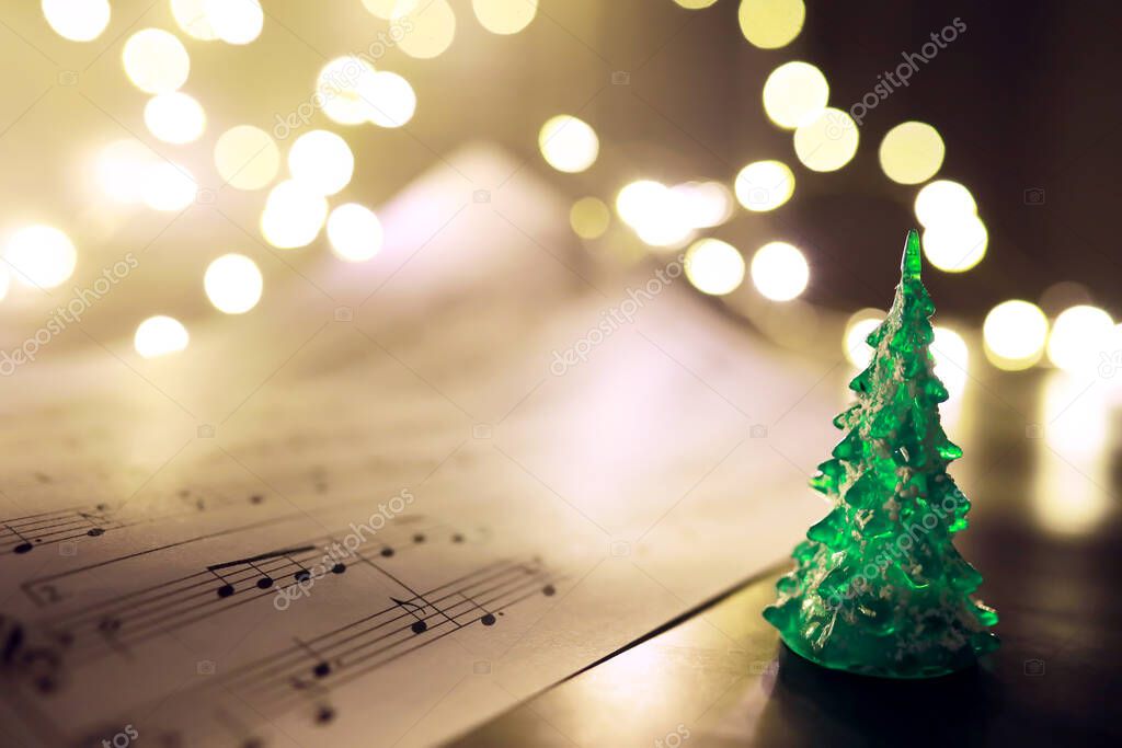 Old sheet with Christmas music notes as background, bokeh effec
