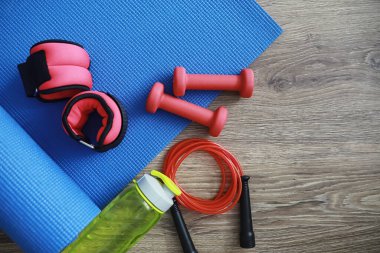 Spor ve sağlıklı yaşam tarzı. Spor aksesuarları. Yoga paspası ve halat atlama. Ev egzersizleri kavramına sahip spor geçmişi.