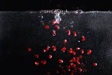 Olgun tatlı nar tohumlarına su damlaları düşer. Metnin için kopyalama alanı olan taze nar arkaplanı. Vejetaryen ve vejetaryen kavramı.