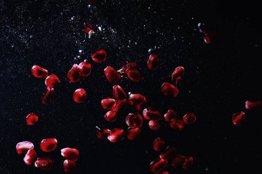 Olgun tatlı nar tohumlarına su damlaları düşer. Metnin için kopyalama alanı olan taze nar arkaplanı. Vejetaryen ve vejetaryen kavramı.