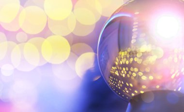 Yerde Bokeh 'le kristal küre var. Renkli ışık saçan cam top, yeni yıl kutlaması konsepti..