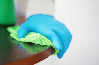 Ev temizliği konsepti. Yüzeylerin tozunu sil. Dezenfektan kapısı TV elektriğini kontrol ediyor. Evdeki karantinada hijyenik tedavi.