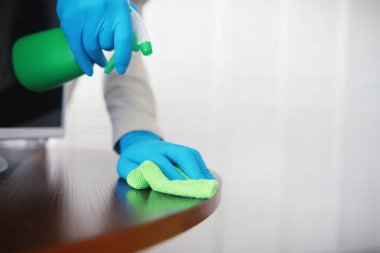 Ev temizliği konsepti. Yüzeylerin tozunu sil. Dezenfektan kapısı TV elektriğini kontrol ediyor. Evdeki karantinada hijyenik tedavi.