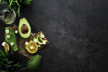 Avokado yemek tarifleri. Tahta kesme tahtasında servis edilen olgun yeşil avokado..