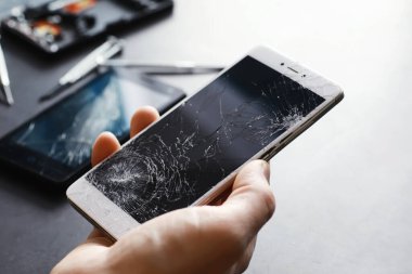 Kırık dokunmatik ekranlı akıllı telefon. Cep telefonu bozuk. Telefon bozuldu. Cep telefonuna kırık cam takmak. Akıllı telefon onarımı.