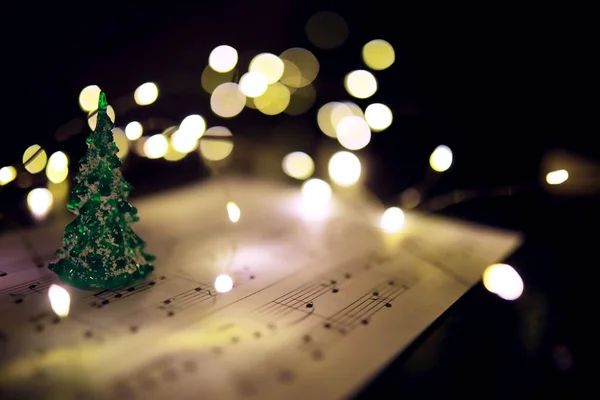 Old sheet with Christmas music notes as background, bokeh effec