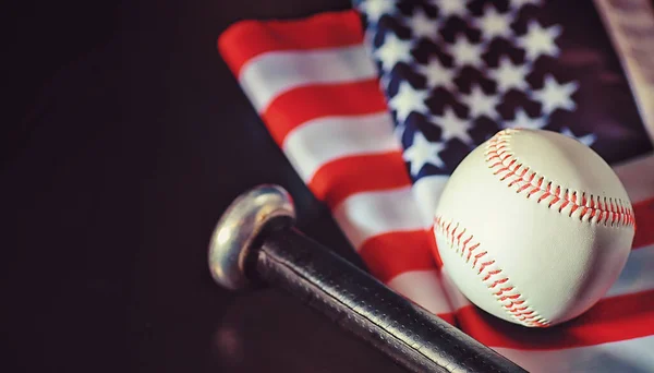 American traditional sports game. Baseball. Concept. Baseball ball and bats on table with american flag.