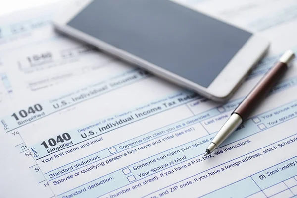 Annual tax reporting. Tax form on the table. Financial statements signature.