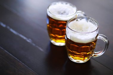 Tahta bir masada bir bardak taze bira. Bira bardağı taş masada. Üst görünüm kopyalama alanı