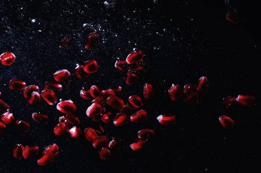 Olgun tatlı nar tohumlarına su damlaları düşer. Metnin için kopyalama alanı olan taze nar arkaplanı. Vejetaryen ve vejetaryen kavramı.