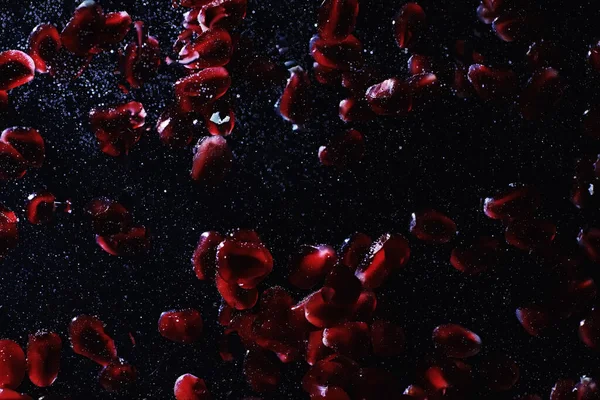 Olgun tatlı nar tohumlarına su damlaları düşer. Metnin için kopyalama alanı olan taze nar arkaplanı. Vejetaryen ve vejetaryen kavramı.