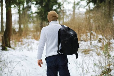 Palto ve İskoç kumaşlı yakışıklı bir adamın açık hava portresi. Kış ormanlarında sakallı adam.