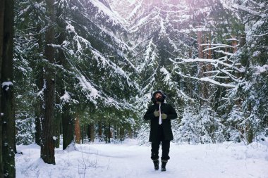 Kış ormanlarında sakallı adam. Çekici, mutlu, sakallı genç bir adam parkta yürüyor..