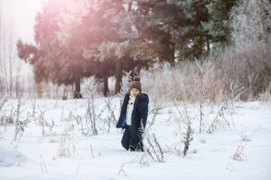 Mutlu bir aile kışın dışarıda karda oynar ve güler. Şehir parkı kış günü