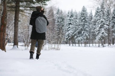 Palto ve İskoç kumaşlı yakışıklı bir adamın açık hava portresi. Sıradan kış modası.