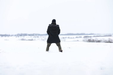 Kış ormanlarında sakallı adam. Çekici, mutlu, sakallı genç bir adam parkta yürüyor..