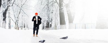 Şemsiyeli bir kış yürüyüşü. Şemsiyeli bir adam, kış manzarasının arka planında yürür, kış manzarası