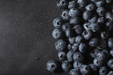 Olgun tatlı yaban mersinine su damlası. Metnin için fotokopi alanı olan taze yabanmersini arkaplanı. Vejetaryen ve vejetaryen kavramı. Yaban mersinli böğürtlenlerin makro dokusu. Yaban mersinli dokular kapanıyor.