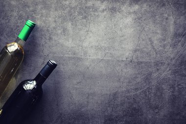 Masada bir bardak kırmızı şarap. Siyah şişe ve bir bardak şarap..