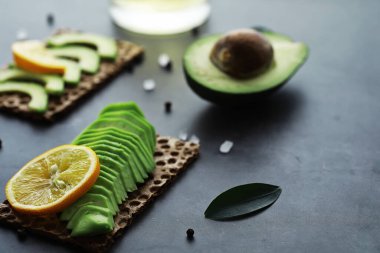 Avokado yemek tarifleri. Tahta kesme tahtasında servis edilen olgun yeşil avokado..