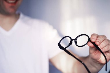 Kötü görüş kavramı. Kontak lens ve gözlüğü elinizde tutun. Reklam gözlükleri ve lensler için poster.