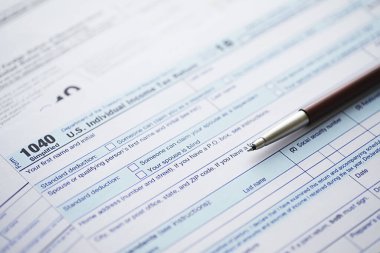 Yıllık vergi bildirimi. Masada vergi formu var. Finansal açıklamalar imzası.