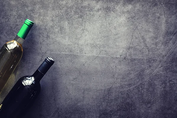 Masada bir bardak kırmızı şarap. Siyah şişe ve bir bardak şarap..