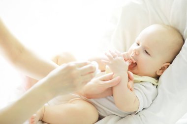 Annelik konsepti. Genç bir anne küçük bebeğini besler. İlk yem ve emzirme. Beyaz elbiseli büyük bir aile..