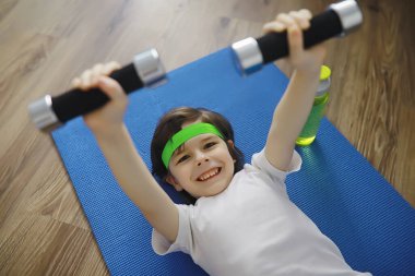 Spor ve sağlıklı bir yaşam tarzı. Çocuk evde spor yapıyor. Yoga paspası ve halat atlama. Ev egzersizleri kavramına sahip spor geçmişi.