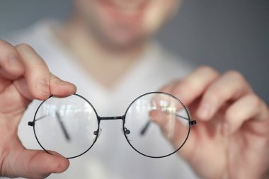 Kötü görüş kavramı. Kontak lens ve gözlüğü elinizde tutun. Reklam gözlükleri ve lensler için poster.