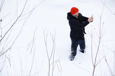 Kışın ormanda bir adam. Sırt çantalı bir turist kışın ormana gider..