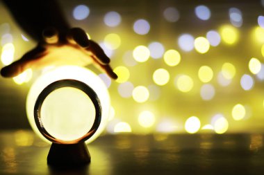 Yerde Bokeh 'le kristal küre var. Renkli ışık saçan cam top, yeni yıl kutlaması konsepti..