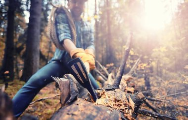 Ormanda ağaç kesen baltalı bir erkek işçi..