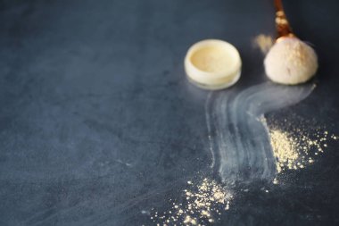 Toz ve makyaj fırçası. Arka planda kahverengi toz. Makyaj ürünleri. Biçim konsepti.