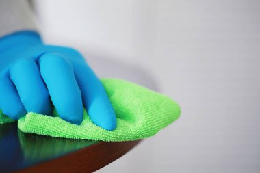 Ev temizliği konsepti. Yüzeylerin tozunu sil. Dezenfektan kapısı TV elektriğini kontrol ediyor. Evdeki karantinada hijyenik tedavi.