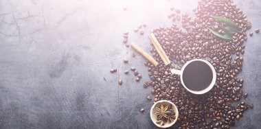 Bir poşet kahve. Kahve çekirdekleri masada kavrulmuş. Pişirmek için yapraklı kahve çekirdekleri.