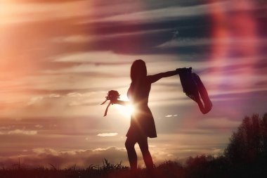 Parkta yürüyüş yapan şapkalı bir kız. Sepetli bir kız sonbaharda yürür. Kız gün batımında yolda yürüyor.