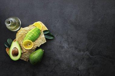 Avokado yemek tarifleri. Tahta kesme tahtasında servis edilen olgun yeşil avokado..