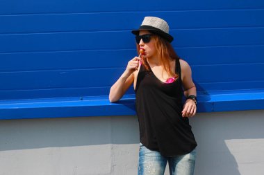 Hafif şapkalı ve güneş gözlüklü bir kız.