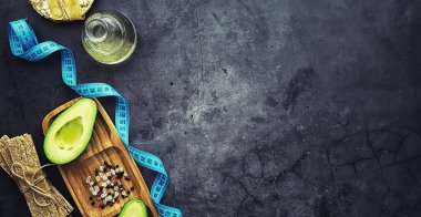 Avokado yemek tarifleri. Tahta kesme tahtasında servis edilen olgun yeşil avokado..