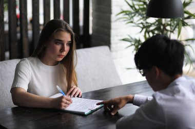 Ofis masasında konuşan bir çift genç.