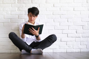 Elinde kitaplarla Asyalı genç bir öğrenci.