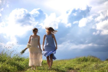 Genç kızlar tarlada Rai 'den önce yürüyor.