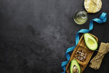 Avokado yemek tarifleri. Tahta kesme tahtasında servis edilen olgun yeşil avokado..