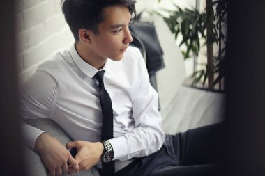 Genç bir Asyalı işadamı bir kafede ortak bekliyor. Bir kafede Koreli genç bir adam telefonda konuşuyor.